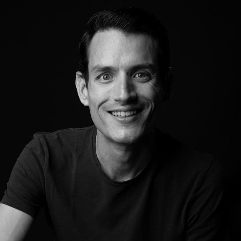 Retrato en blanco y negro de Sebastián Delsalto, fundador de Daleki Art, sonriendo sobre un fondo negro